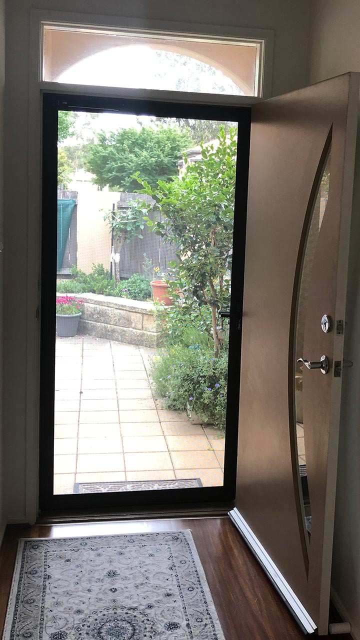 Black sliding security door with lock and mesh by Thomo's Home Improvements