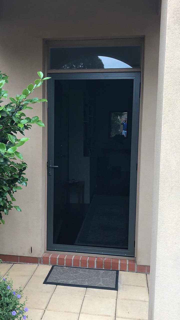 White hinged security door with diamond grille by Thomo's Home Improvements