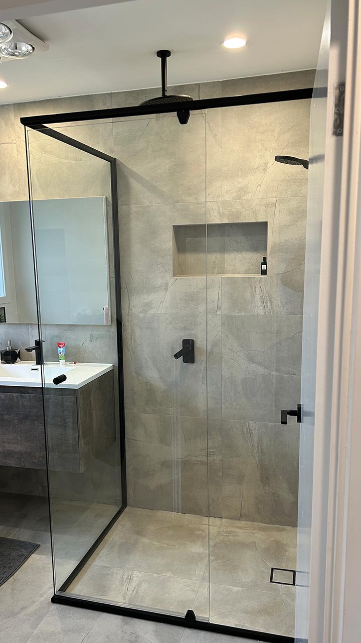 Frameless corner shower screen with clear glass panels by Thomo's Home Improvements Canberra
