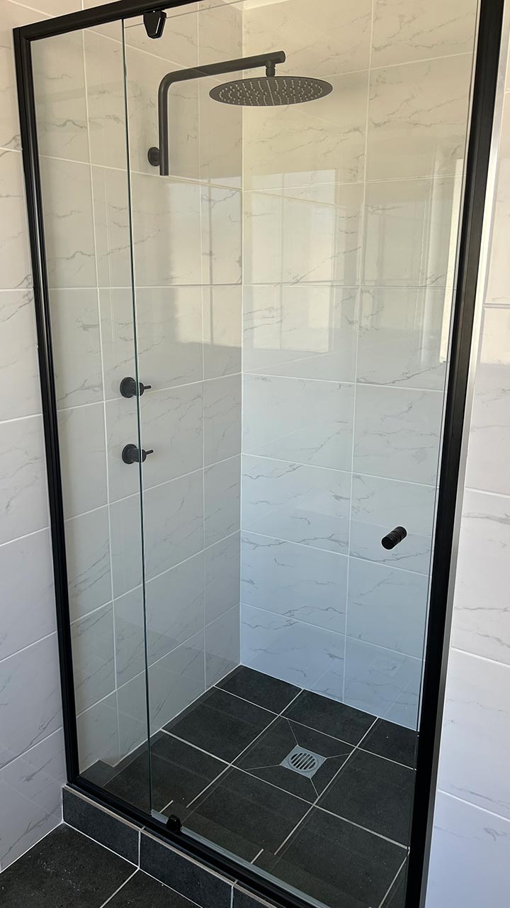Framed sliding shower screen with white frame by Thomo's Home Improvements Canberra