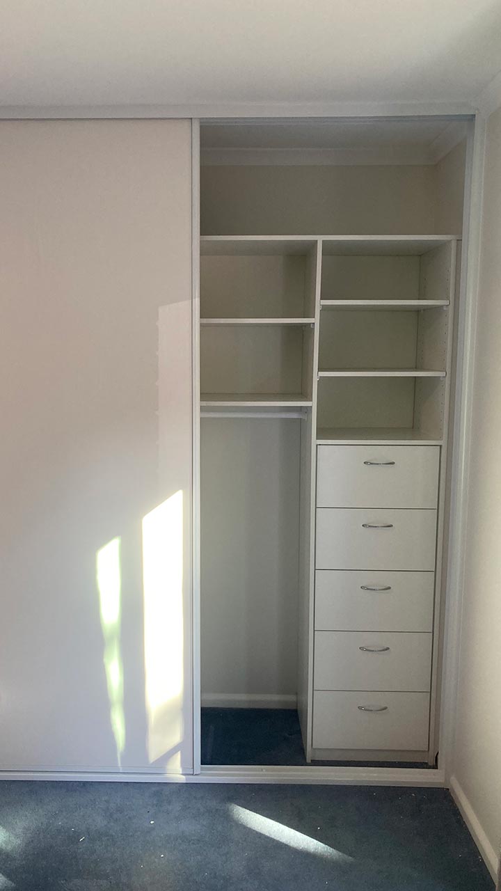 Walk-in wardrobe with hanging rails, shelving and drawers by Thomo's Home Improvements Canberra