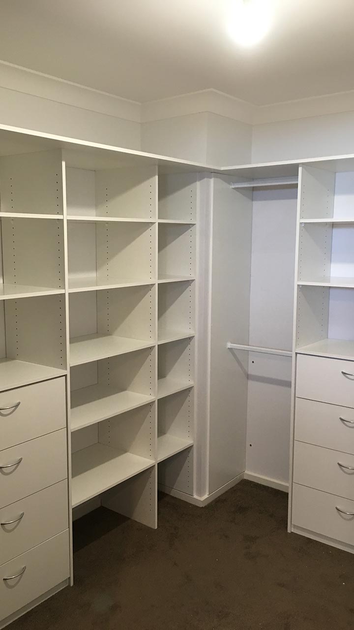 Custom built-in wardrobe with white sliding doors, shelving and drawers by Thomo's Home Improvements