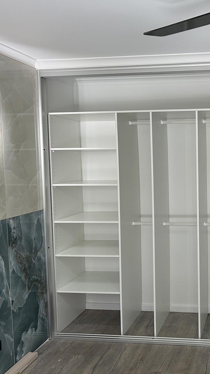 Built-in wardrobe with timber sliding doors and internal shelving by Thomo's Home Improvements