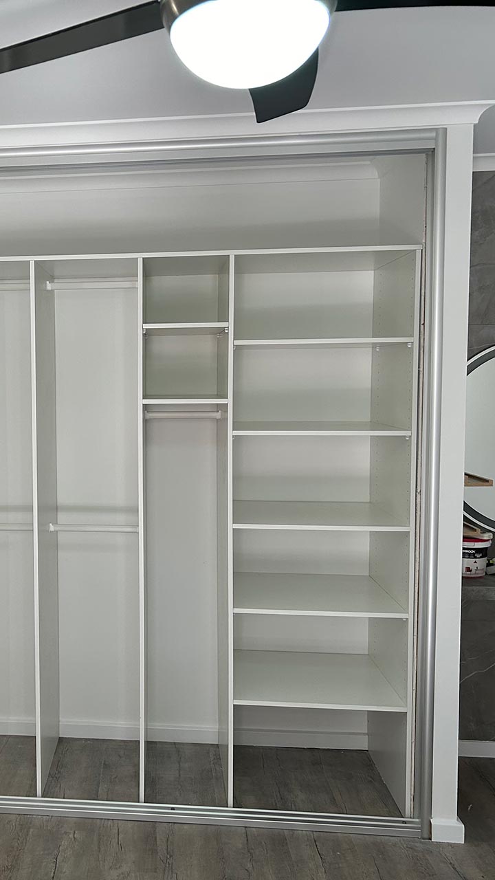Custom walk-in wardrobe with drawers, shelving and full hanging rails by Thomo's Home Improvements