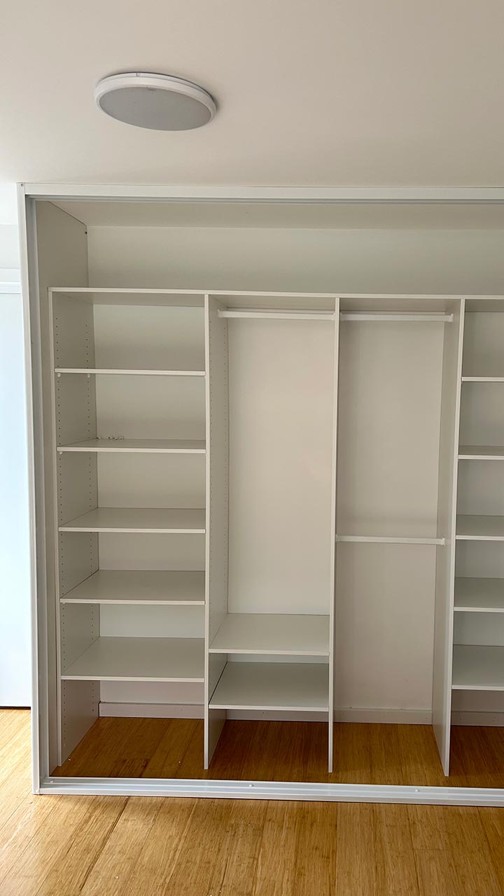 Walk-in wardrobe with corner shelving, drawers and hanging rails by Thomo's Home Improvements