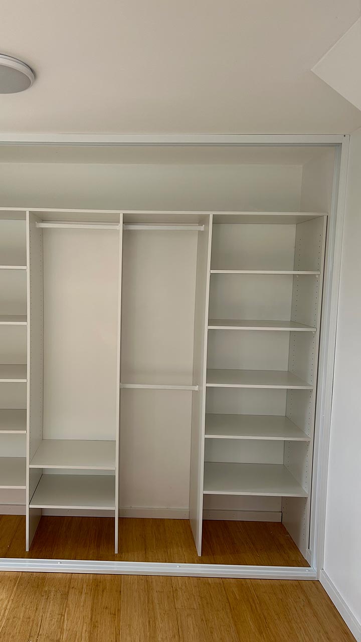 Built-in wardrobe with glass sliding doors and storage shelves by Thomo's Home Improvements